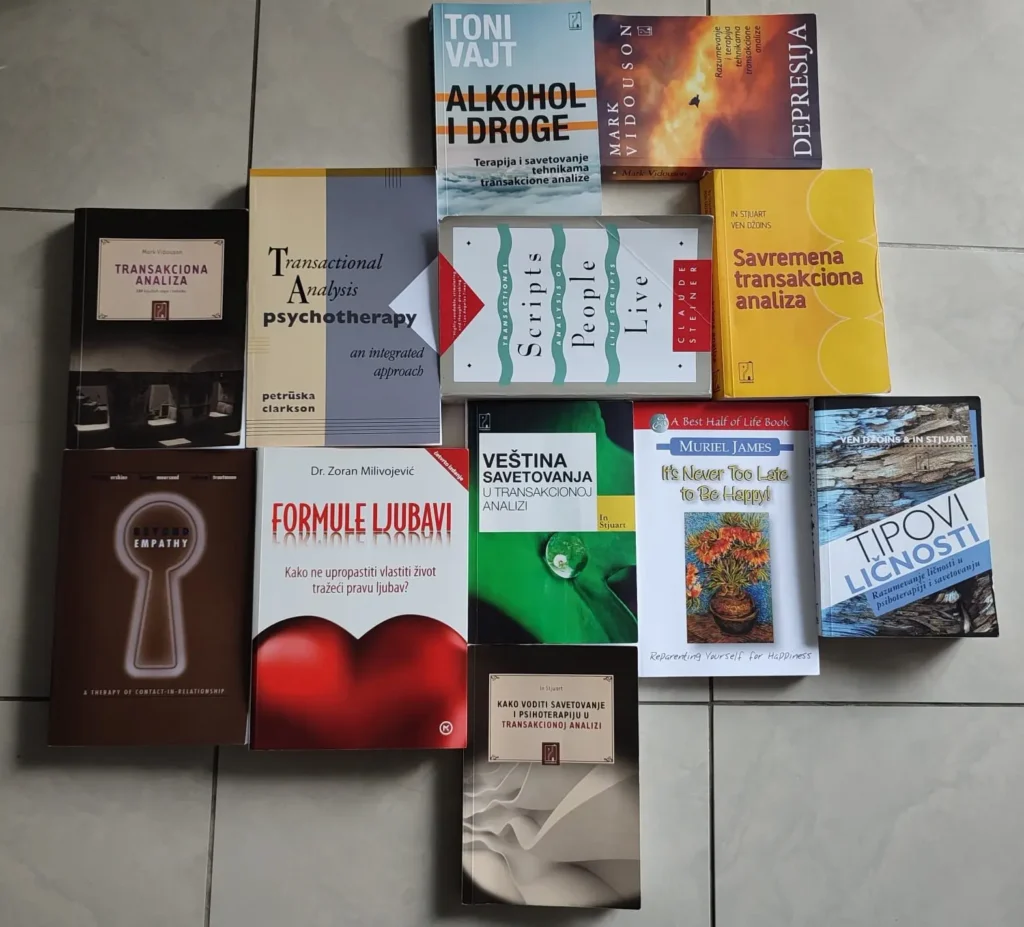 Stack of books on Transactional Analysis, including classic and modern texts on psychotherapy and personal development.