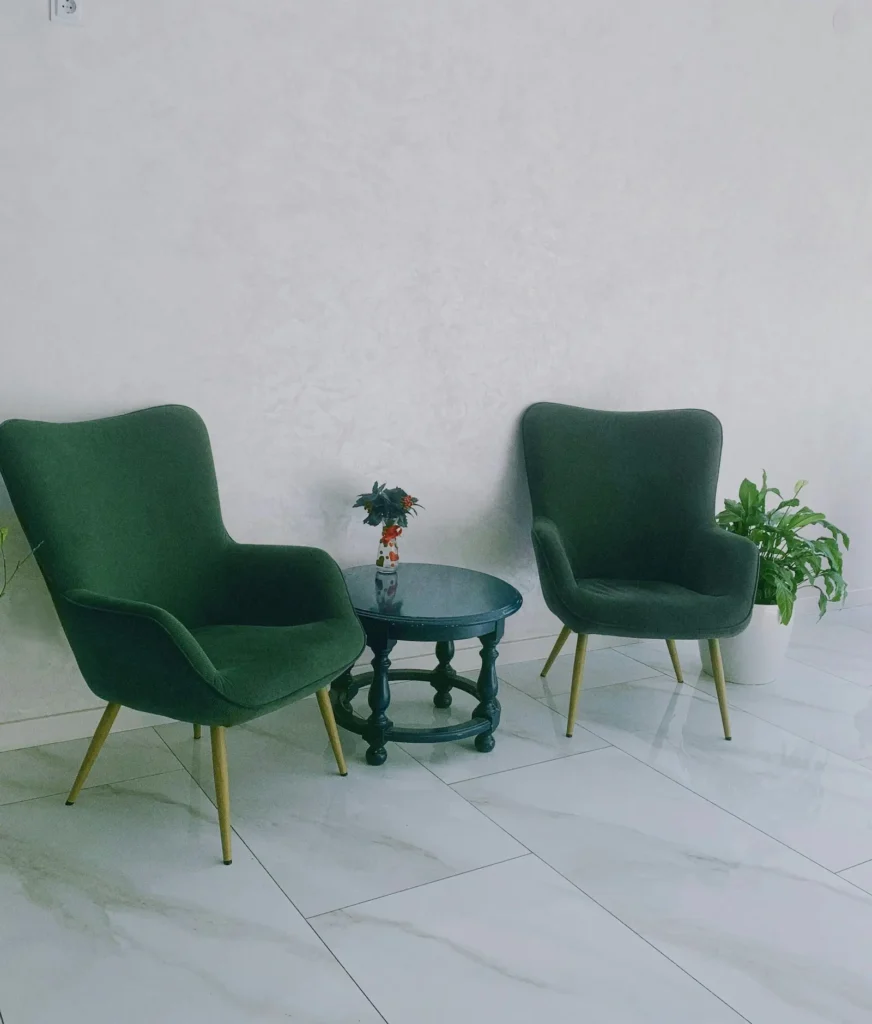 Dvije prazne fotelje u toplom ambijentu, postavljene nasuprot jedna drugoj. Slika simbolizira prostor psihoterapije – odnos povjerenja, sigurnosti i osobnog rasta.